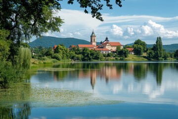 Obraz premium Scenic view of the benedictine abbey in tihany reflecting on lake balaton under a cloudy sky