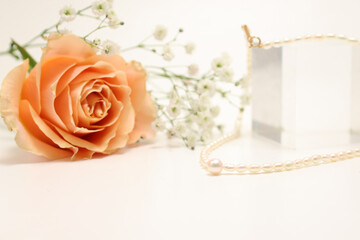 真珠のネックレスと薔薇とカスミソウの花束