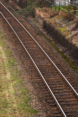 Obraz premium railroad tracks stretching into the distance with dry vegetation.
