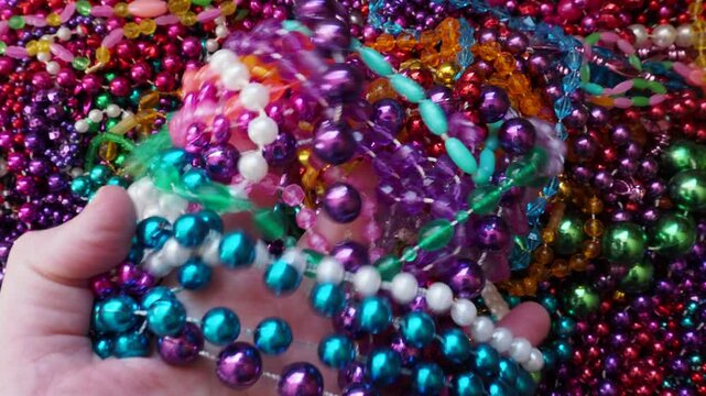 Grabbing a Handful of Colorful Mardi Gras Beads, first person POV