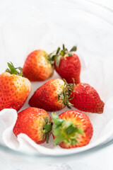 Fresh and Moldy Strawberries in a Glass Bowl on a White Napkin