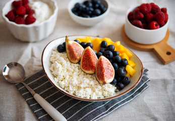 Cottage cheese with berries. Bowl of cottage cheese with mango, blueberry and fig,  healthy breakfast or lunch
