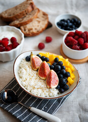 Cottage cheese with berries. Bowl of cottage cheese with mango, blueberry and fig,  healthy breakfast or lunch