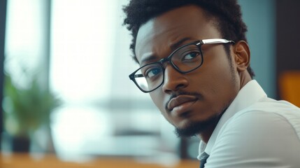 Obraz premium Young African entrepreneur looking thoughtful in office