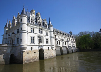 Obraz premium White stone chateau with turrets Elegant chateau of white stone and rounded turrets, arched windows and formal entrances framed by manicured lawns.