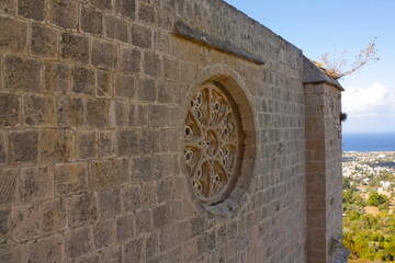 Tracery medallion view Small circular window with lace-like stone tracery framed by rough masonry.