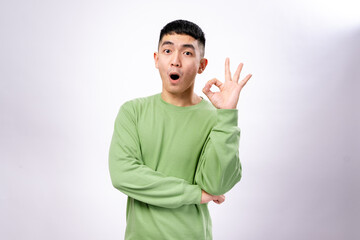 An Asian man in a green sweatshirt makes an 