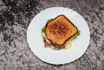 Delicious Melted Cheese and Bacon Sandwich on a Plate