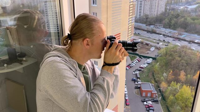 A man take photo of cityscape sunset from apartment balcony
