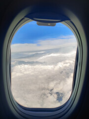 Fototapeta premium beautiful thick clouds in the sky from the height of the flight of the plane with a view of the wing with engines through the round window