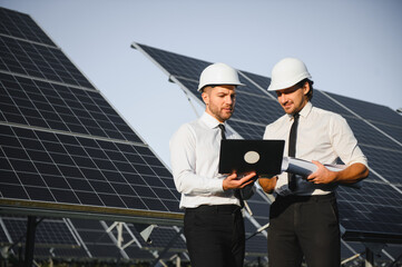 Portrait of engineers standing outside near solar panels