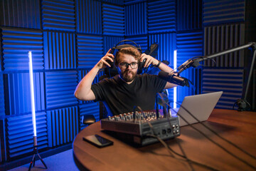 Handsome man radio DJ hosting a radio show, entertainment and communication concept