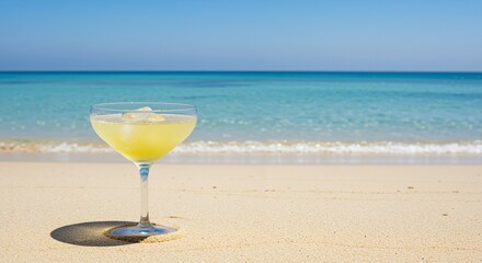Refreshing margarita cocktail in a crystal glass with ice on a sunlit sandy beach under a clear blue sky