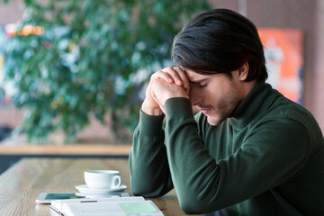 Desperate man touching his head, businessman having hard time, working at cafe, copy space