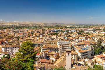 Granada town in Spain. Panoramic view of a historic city under a clear blue sky.  Distant hills and plains are visible.