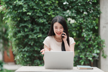 Enthusiastic Communicator: A vibrant woman, engrossed in a phone conversation, works on her laptop...