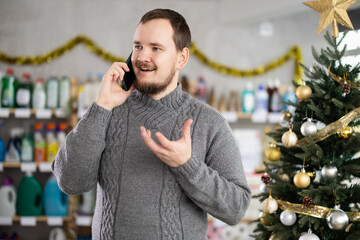 Man talks on his mobile phone while shopping in a supermarket