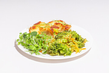 A well-lit close-up of a golden, crispy fish fillet with fresh greens and vibrant vegetables.