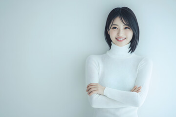 Portrait of a beautiful woman smiling, wearing a white turtleneck sweater, standing with her arms crossed