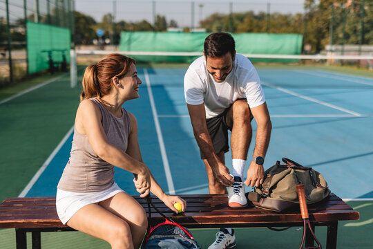 Young couple playing tennis outdoors enjoying a fun summer game