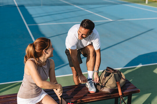 Young couple playing tennis outdoors enjoying a fun summer game