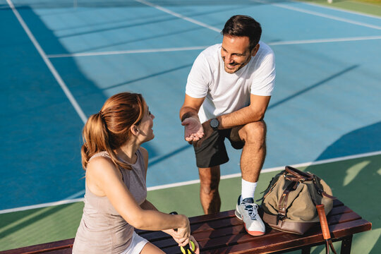 Young couple playing tennis outdoors enjoying a fun summer game