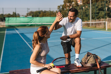 Young couple playing tennis outdoors enjoying a fun summer game