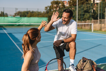 Young couple playing tennis outdoors enjoying a fun summer game