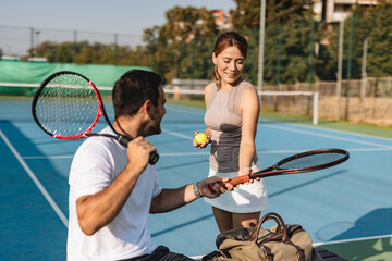 Young couple playing tennis outdoors enjoying a fun summer game