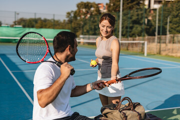 Young couple playing tennis outdoors enjoying a fun summer game