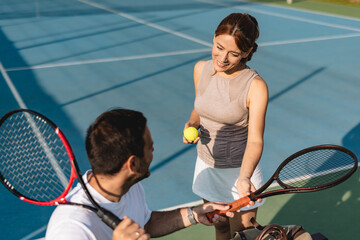 Young couple playing tennis outdoors enjoying a fun summer game