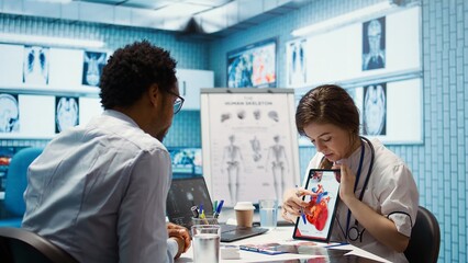 Healthcare provider cardiologist explains heart function on a cardiogram, doctor patient...