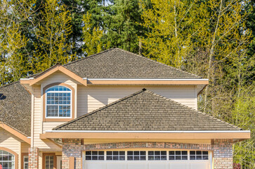 Top of luxury house with shingle roof, red and yellow trees and nice windows in Summer in...