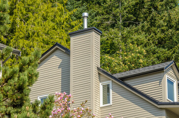 Top of luxury house with shingle roof, red and yellow trees and nice windows in Summer in...