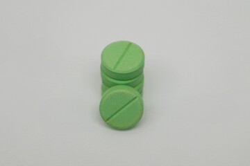 Expired green medicine tablets on white background