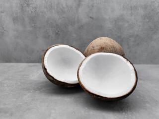Fresh coconuts showing white flesh on gray background. Copy space, banner
