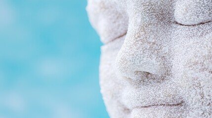 Fototapeta premium Woman's face covered in white powder, relaxed expression, against teal background, beauty treatment