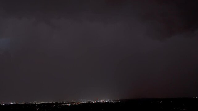 Dark storm clouds rolling in with electric lightning flashes over the city.