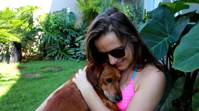 mulher faz carinho em cachorro caramelo 