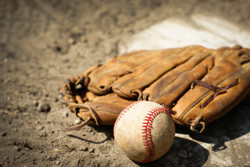 Baseball and mitt on home plate and field