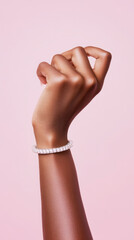 Elegant display of a hand with a sparkling bracelet against a soft pink background