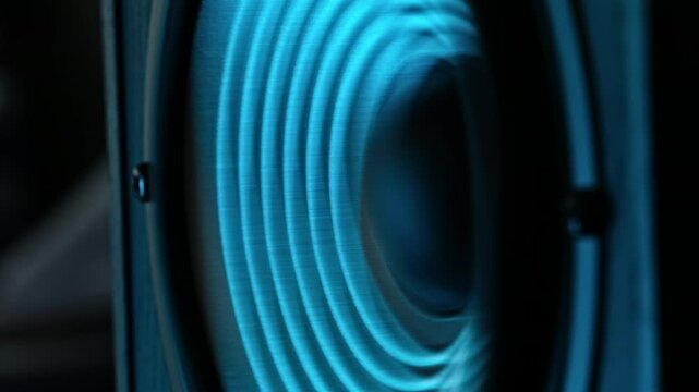 Bass Speaker Vibrating To Music Under Blue Light