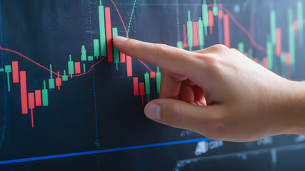 A close-up of hands pointing at stock market candlestick charts, illustrating market trends, price movements, and financial trading analysis.