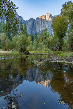 Merced River in yosemite national park with waterfall in background.