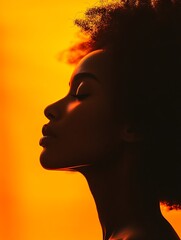 Profile of a woman, meditating, in studio, warm orange background