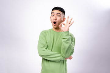An Asian man in a green sweatshirt makes an 