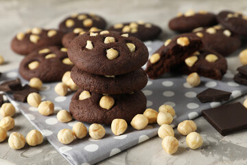 Tasty chocolate cookies with hazelnuts on grey table, closeup
