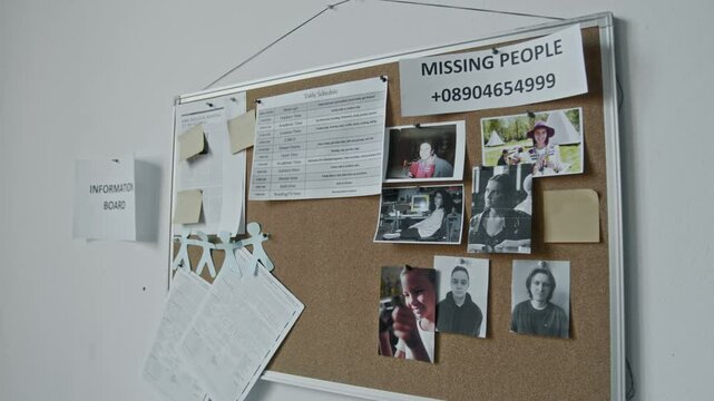 Medium closeup side shot of information board in refugee shelter during war, natural disaster or emergency, with photos of missing persons, daily schedule of facility, fake hotline phone number