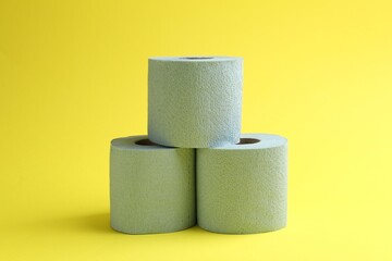 Light blue toilet paper rolls on yellow background