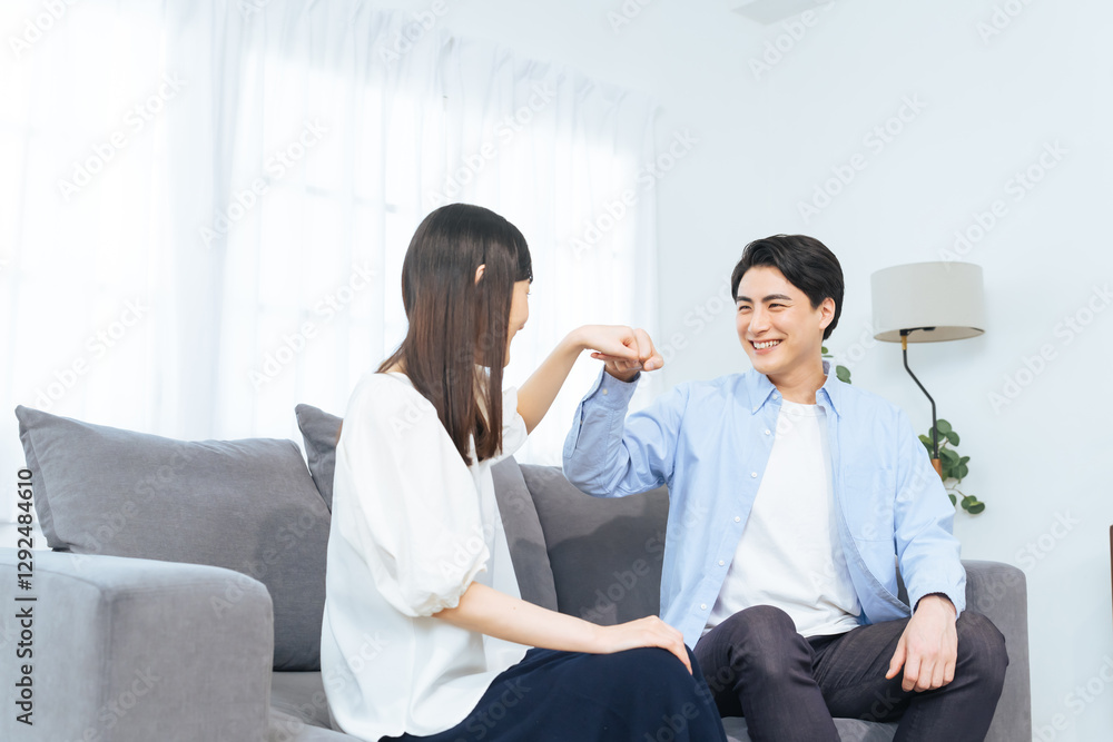 Leinwandbilder カップル、夫婦、男女、人物、グータッチ、応援、祝福、感謝、笑顔、チームワーク、ポジティブ、仲良し、女性、男性、日本人、ソファー、リビングルーム、暮らし、ライフスタイル、住宅、同居、プロポーズ、結婚、婚活、新婚、サポート、助け合い、成功、元気、若い、安心、信頼、関係、お祝い、励ます、恋人、愛情、家族、家庭、和解、喜ぶ、嬉しい、ハッピー、同棲、マッチング、相性、パートナー、仲間、約束